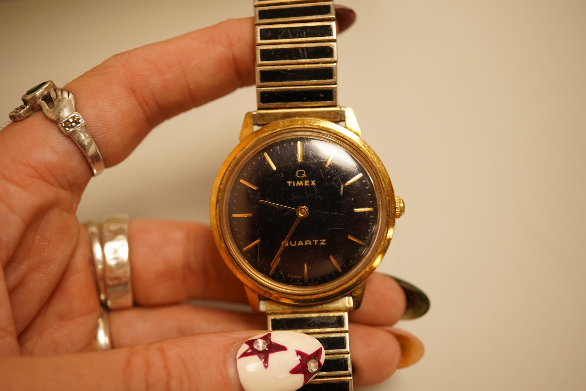 A collection of coins, notes and wrist watches